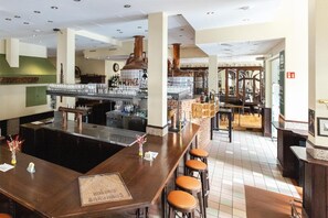 Eine Bar mit Hockern, einer Theke und einer großen Kupferbrennvorrichtung.