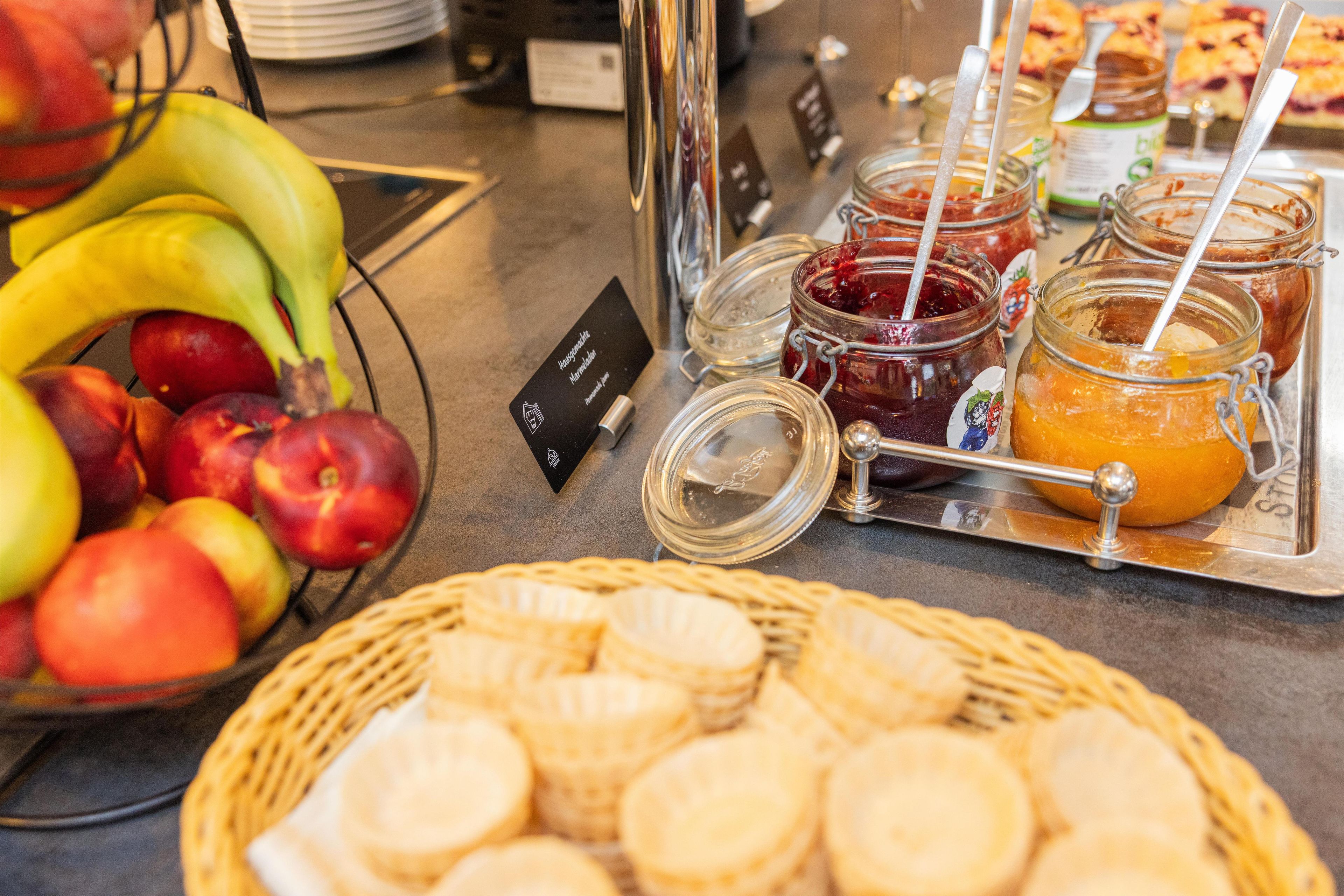 Ein reichhaltiges Buffet mit Früchten, Marmeladen und Gebäck.