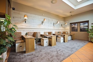 Una habitación con muebles de madera, alfombra gris y lámparas de pared.