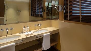 Ein Badezimmer mit zwei Waschbecken, einem Spiegel und einer Dusche.