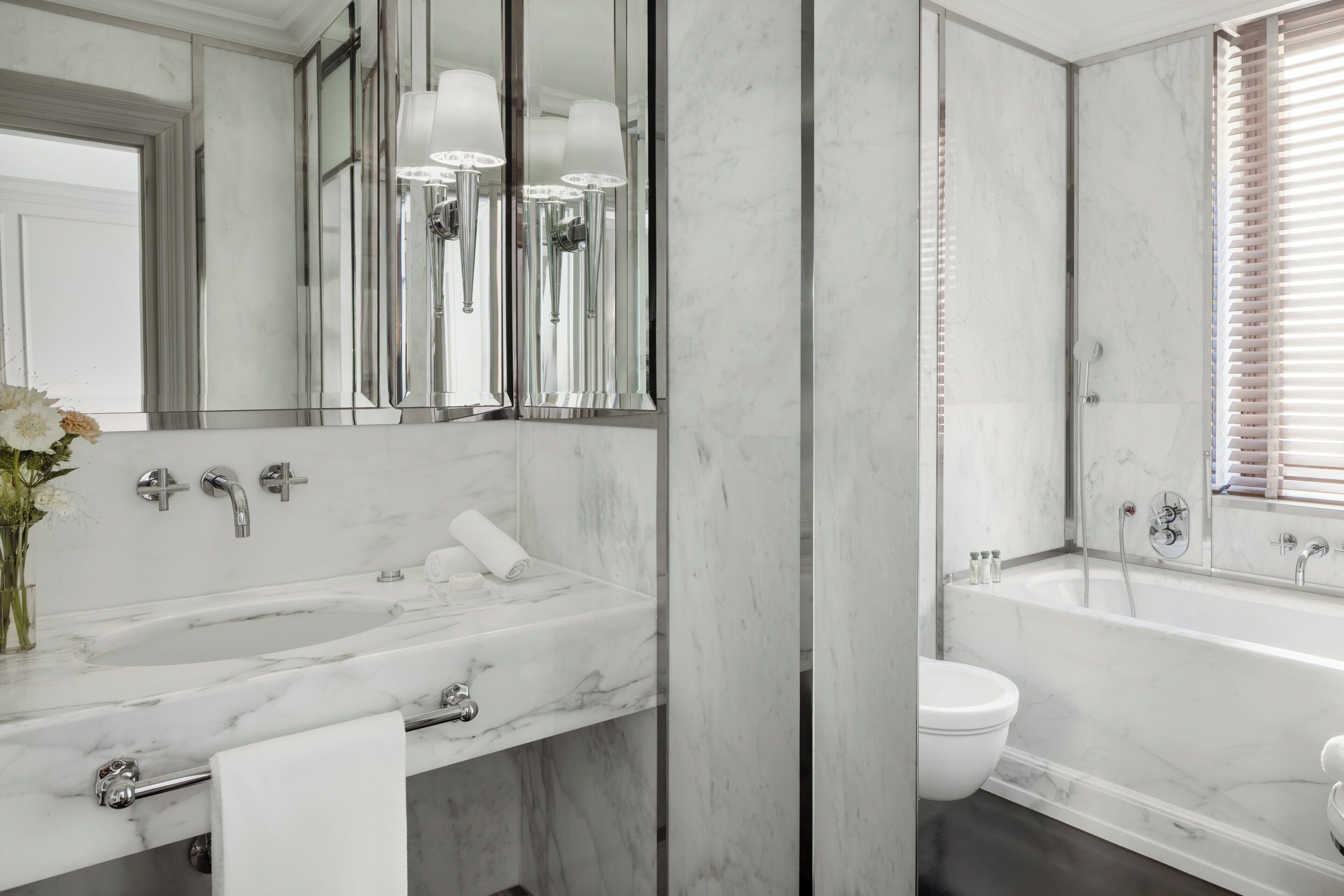 A bathroom with a large marble sink, a bathtub, and a toilet.