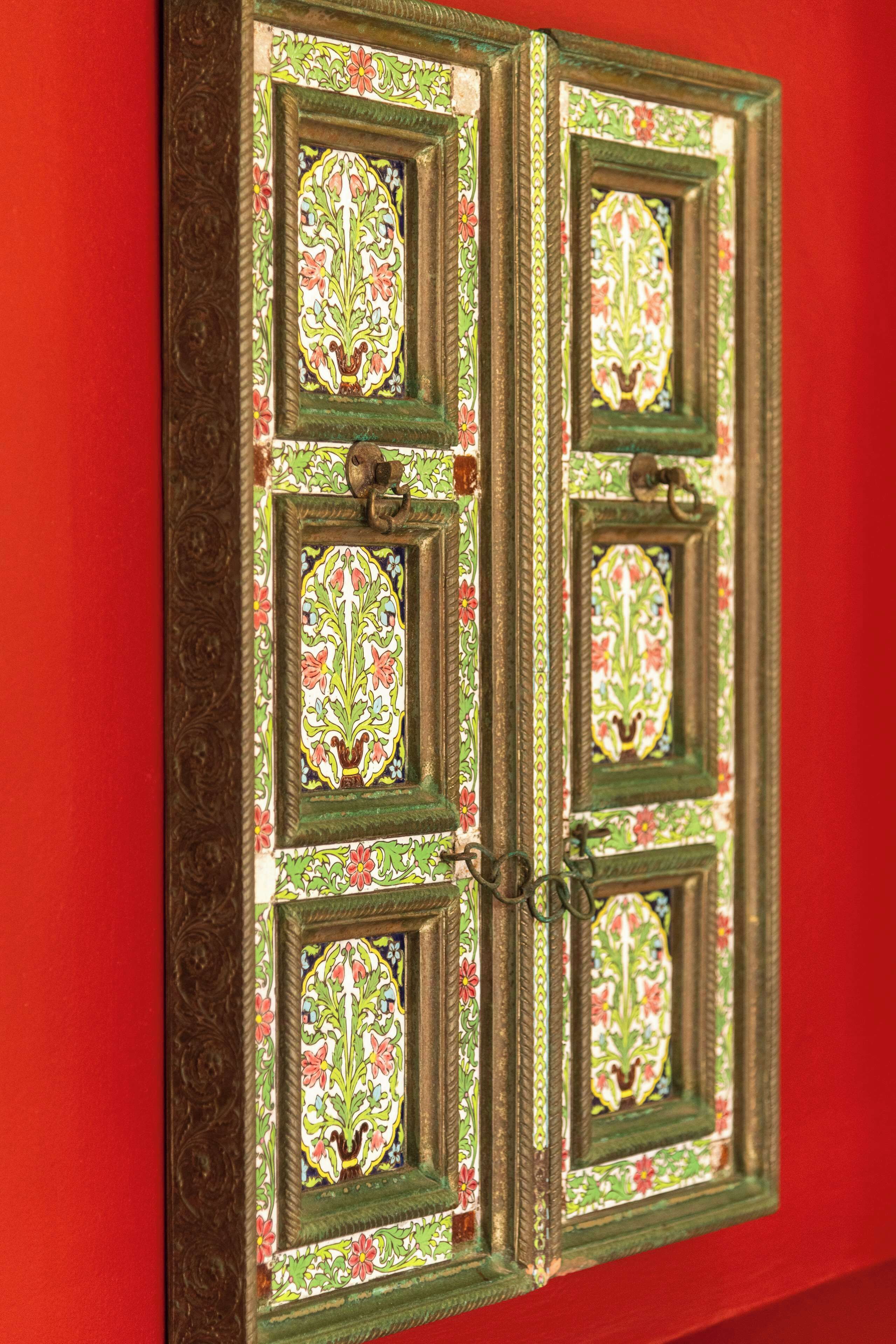 Una porta con decorazioni floreali elaborate e una maniglia in ottone.