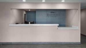 A reception desk with a blue wall and a logo that reads 'Baymont by Wyndham.'