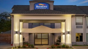 A Baymont by Wyndham hotel with a modern facade, large entrance, and well-lit exterior.
