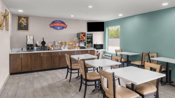 A breakfast area with a counter, seating, and a sign reading 'Baymont Breakfast Corner'.