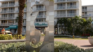 Ein mehrstöckiges Hotel mit Balkonen, einer Palme und einem Schild mit der Aufschrift 'BeachView'.