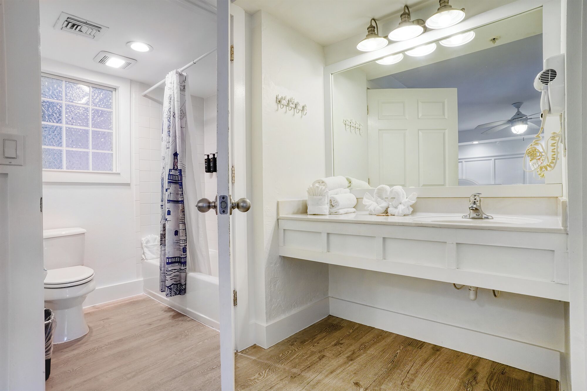 A bathroom with a white sink, mirror, and towel rack.