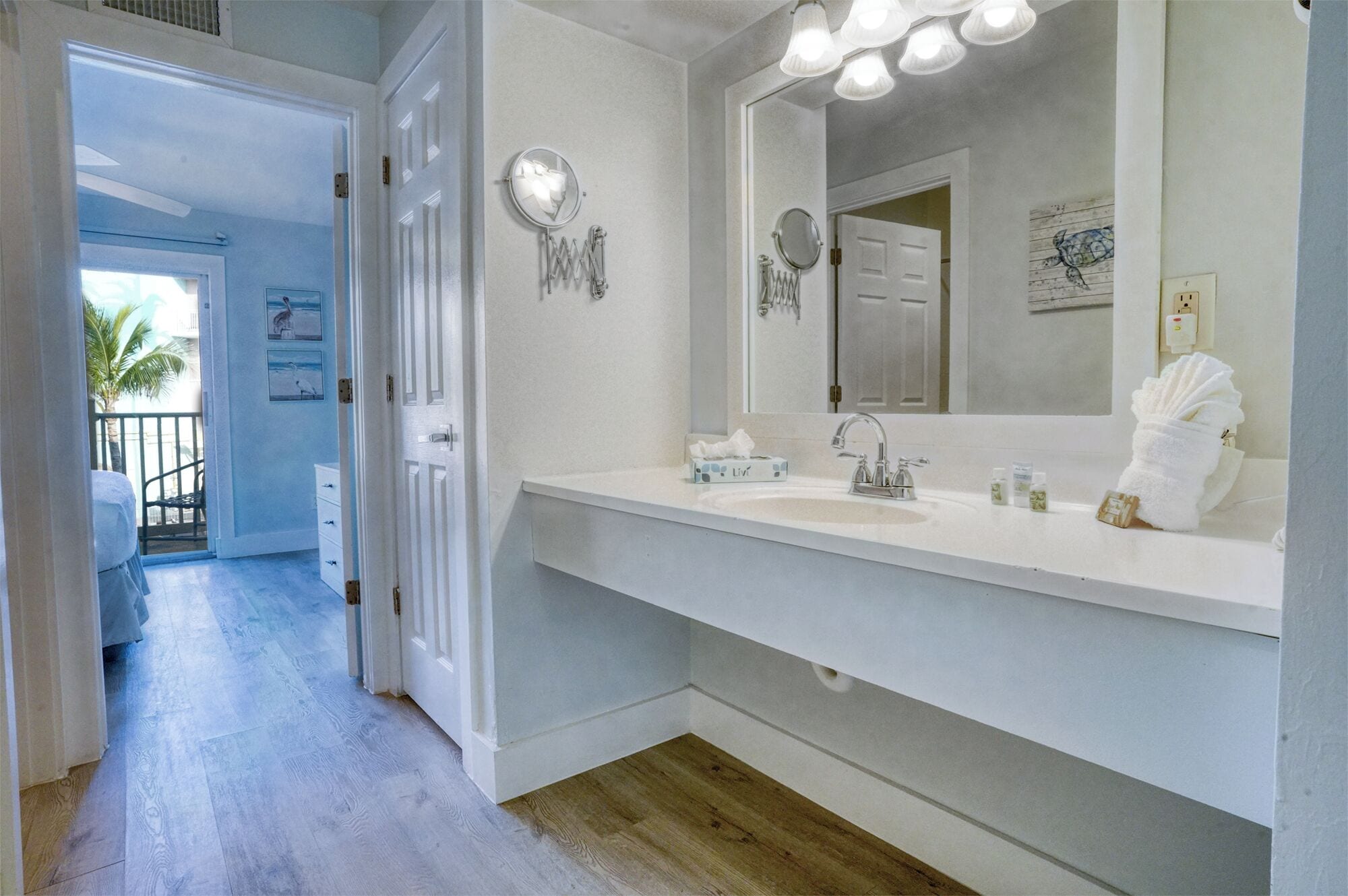 A bathroom with a white sink, a large mirror, and a towel rack.