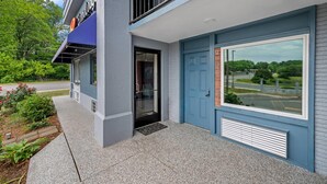 A modern building with a blue door and a large window. - Econo Lodge Charlotte Airport Area (Charlotte)