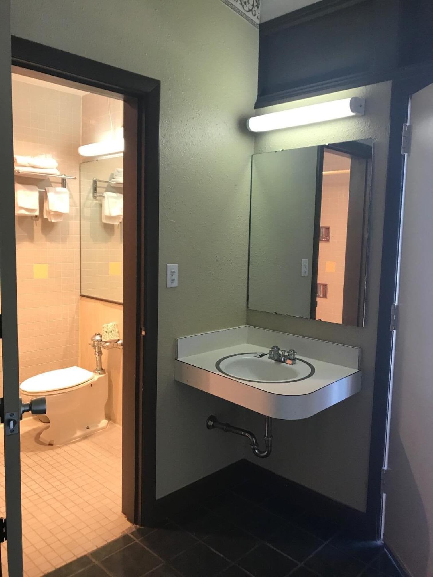 Un baño con inodoro, lavabo y espejo.