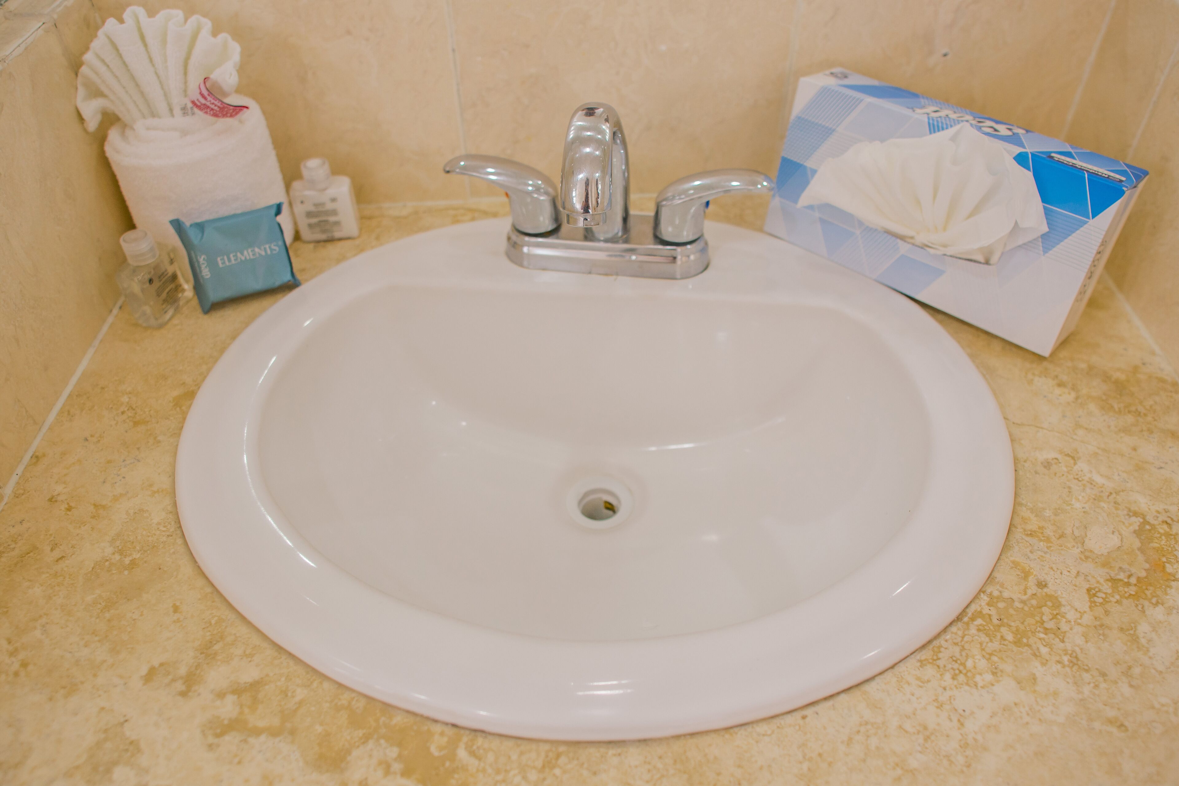 Un lavabo de salle de bain avec un miroir, une serviette et des articles de toilette.