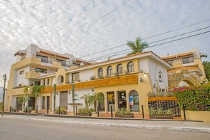 Un hotel con fachada amarilla, varios balcones y un cartel que dice 'Santa Fe'.