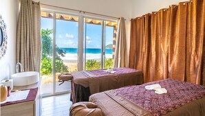 Une chambre avec deux lits, une salle de bain et vue sur la plage.