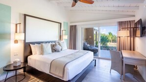 Une chambre d’hôtel avec un grand lit, un bureau et un ventilateur de plafond.