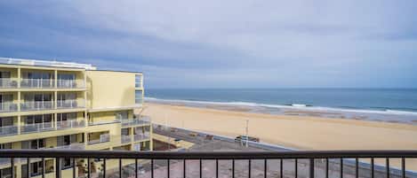 Ein Strandhotel mit mehreren Balkonen mit Blick auf den Ozean.