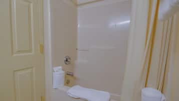 Un baño con bañera, cortina de ducha y un perchero para toallas.