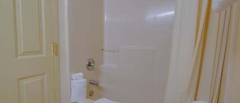 Un baño con bañera, cortina de ducha y un perchero para toallas.