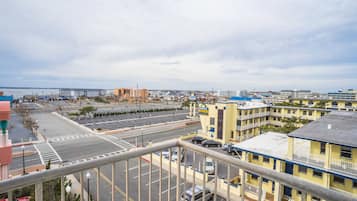 A hotel with multiple floors, a parking lot, and a view of the cityscape and coastline.