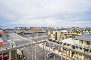 Um hotel com vários andares, estacionamento e vista para a cidade e a costa.