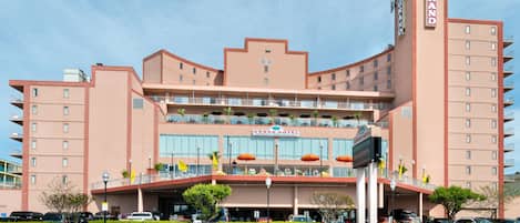 A multi-story hotel with a terrace restaurant, balconies, and a prominent sign.