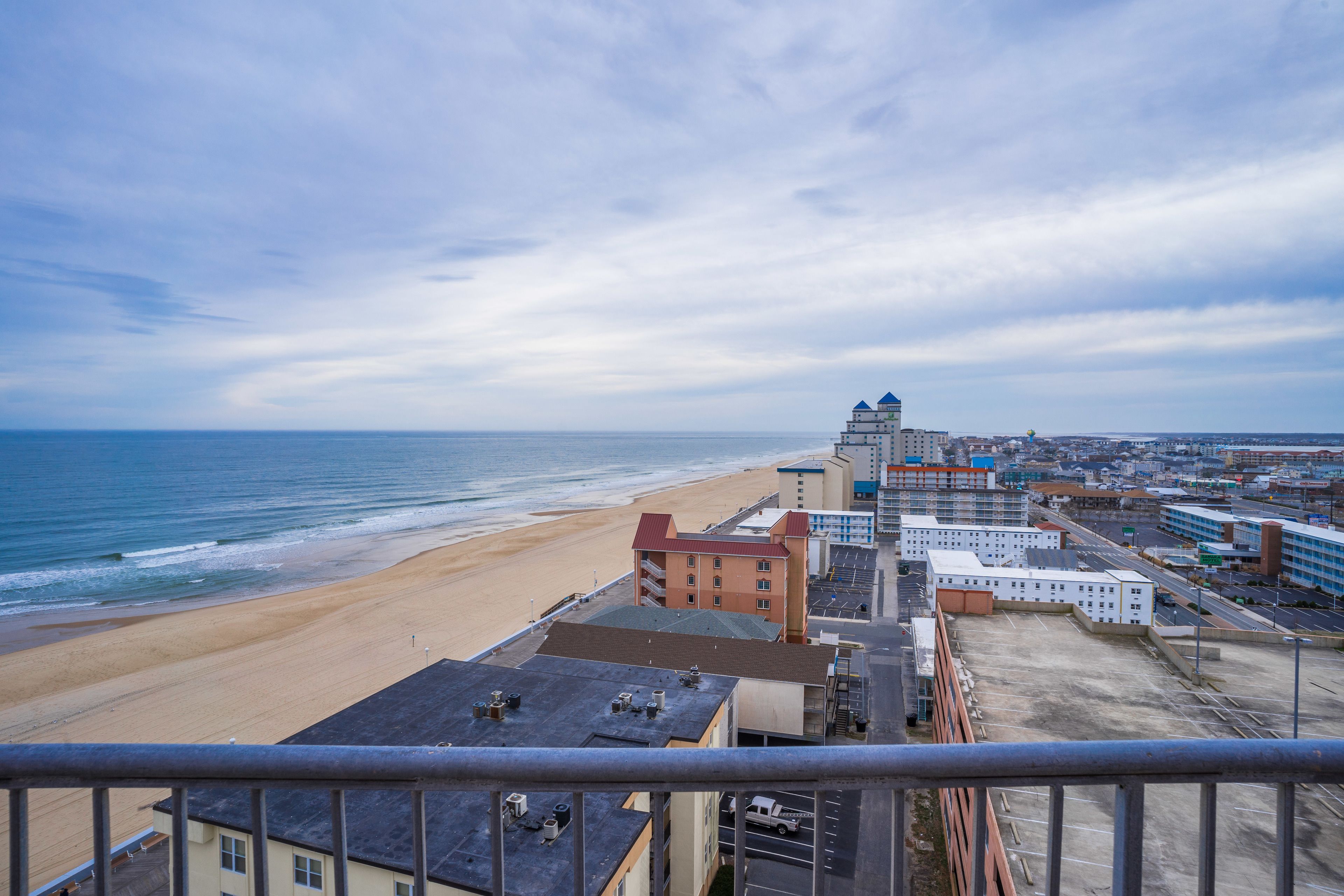 Un paysage urbain côtier avec une plage, des bâtiments et un ciel dégagé.