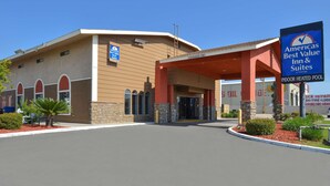 A hotel with a clear entrance, a sign indicating an indoor heated pool, and a sign for the Americas Best Value Inn & Suites.