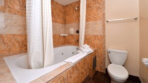 A bathroom with a bathtub, a toilet, and a shower curtain.