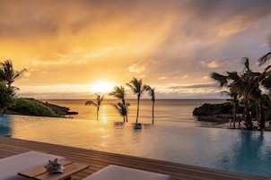 Una piscina al aire libre, sombrillas, sillones reclinables de piscina