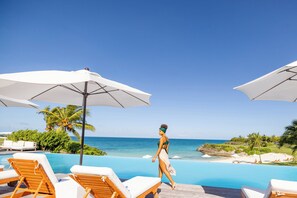 Een buitenzwembad, parasols voor strand/zwembad