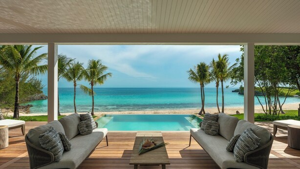 A covered outdoor seating area with a pool, overlooking a beach and ocean. - The Cove Eleuthera (Gregory Town)