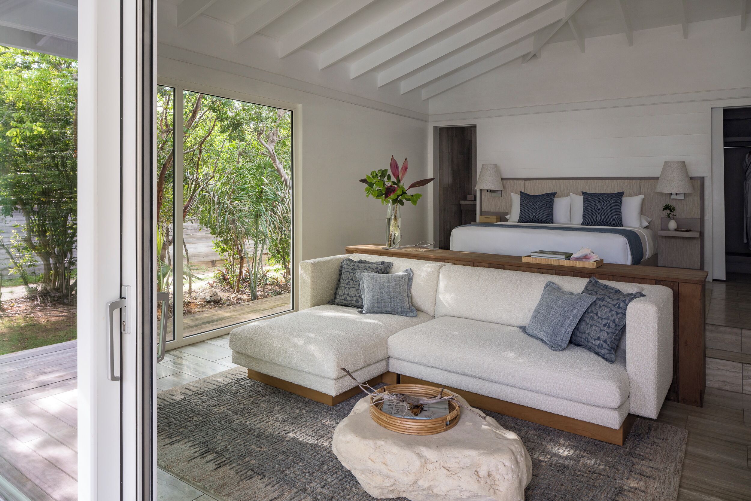 A modern bedroom with a large bed, a sofa, and a coffee table.