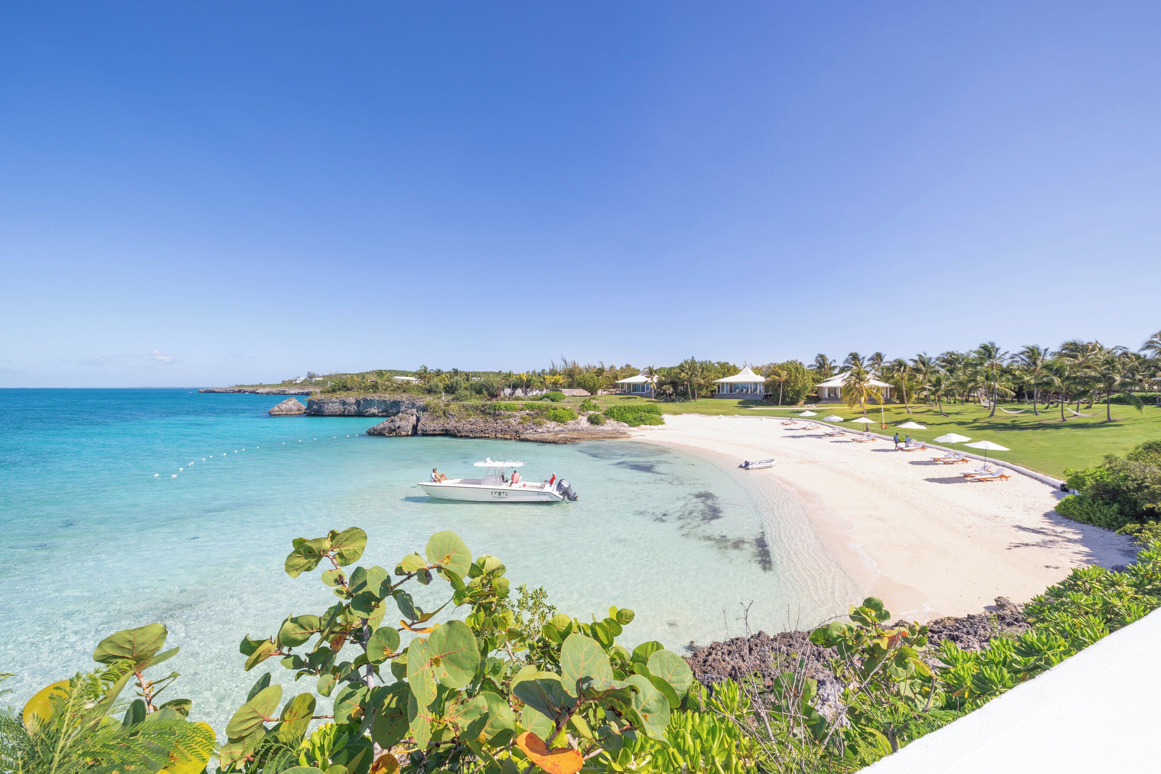 Un complexe hôtelier de bord de mer offrant des eaux turquoise cristallines, une plage de sable fin et une végétation luxuriante.