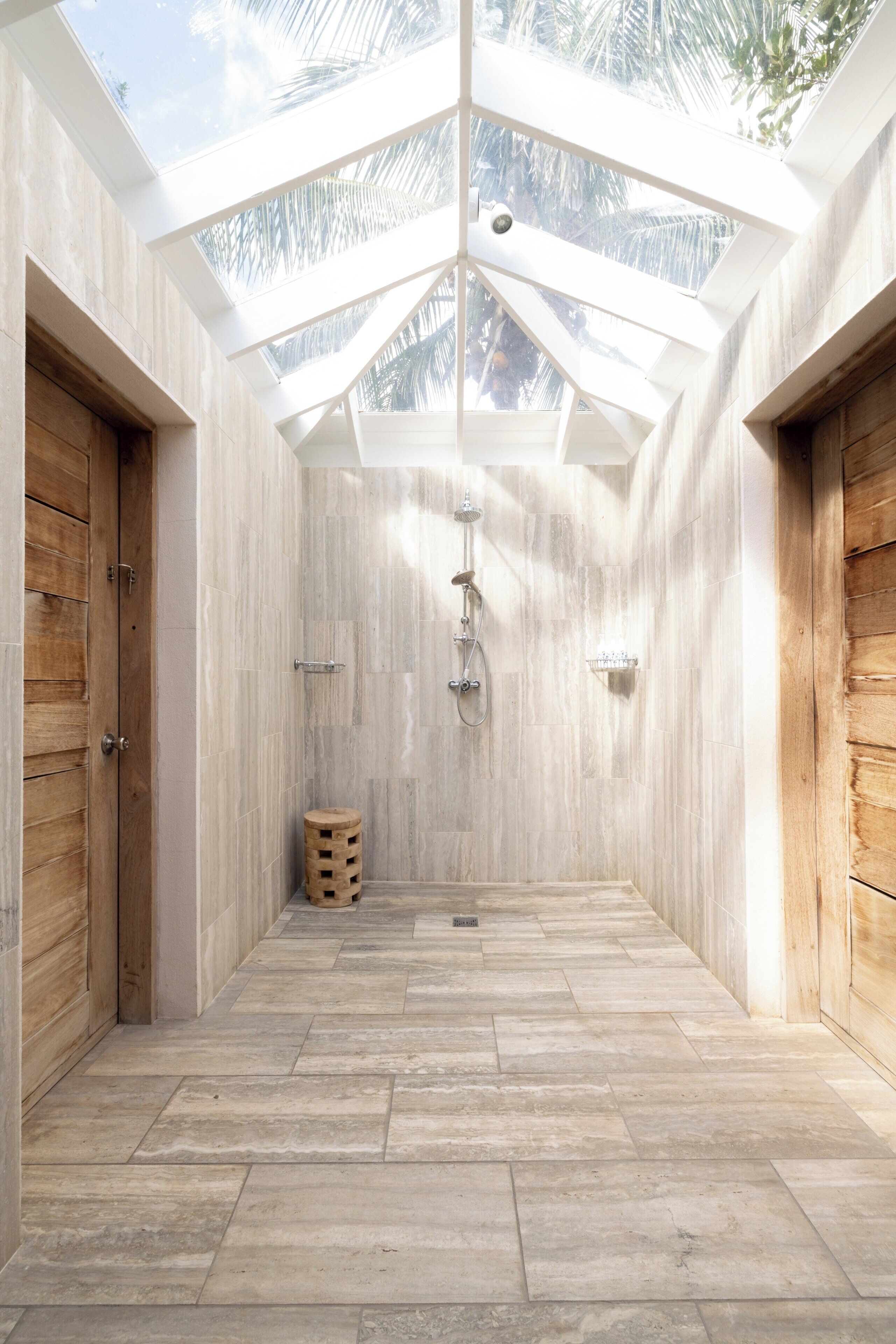 Un baño moderno con tragaluz, puertas de madera y suelo de baldosas.
