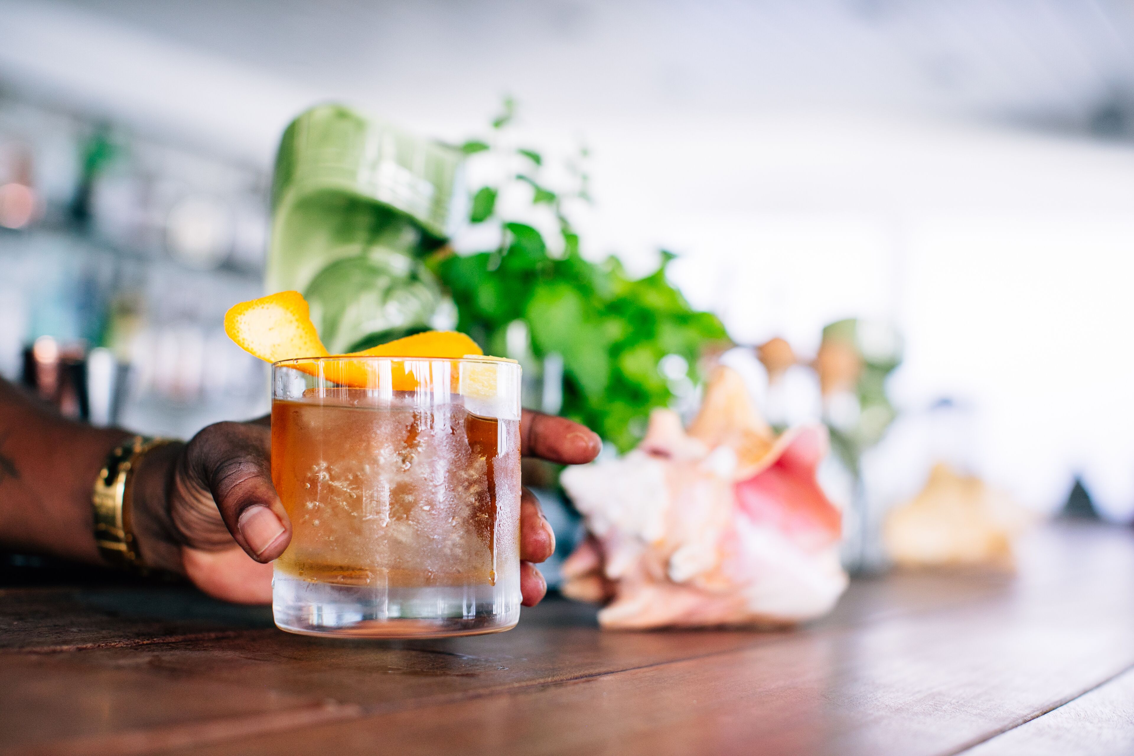 Une personne tenant un verre décoré d’une tranche de citron.