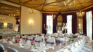 A banquet hall with long tables set for a formal event, chandeliers, and large windows with curtains. - Mercure Sheffield Kenwood Hall & Spa (Sheffield)