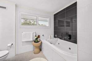 A bathroom with a toilet, bidet, bathtub, and window blinds. - Best Western Plus Apollo Hotel Newcastle (Charlestown)