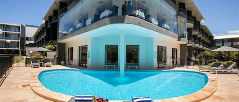 Una piscina al aire libre, sombrillas