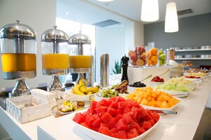 A buffet with various fruits and beverages.