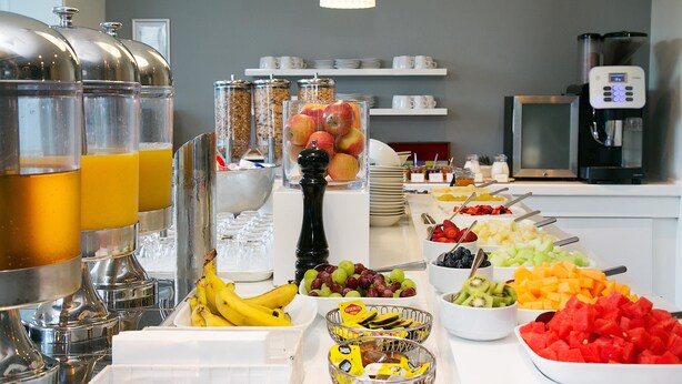 Un bufé con diversas frutas, verduras y bebidas.