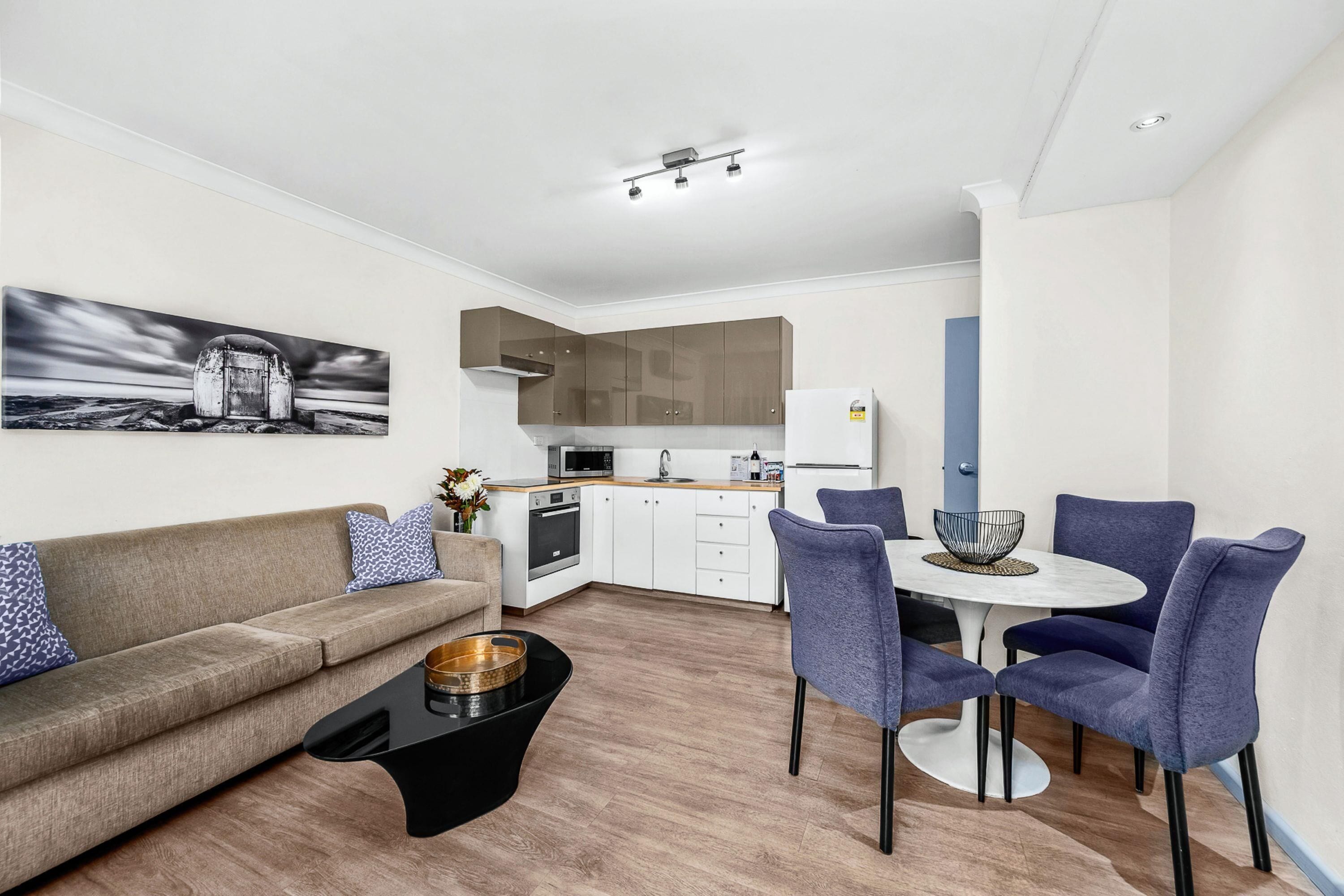 A modern apartment with a living area, kitchen, and dining space.