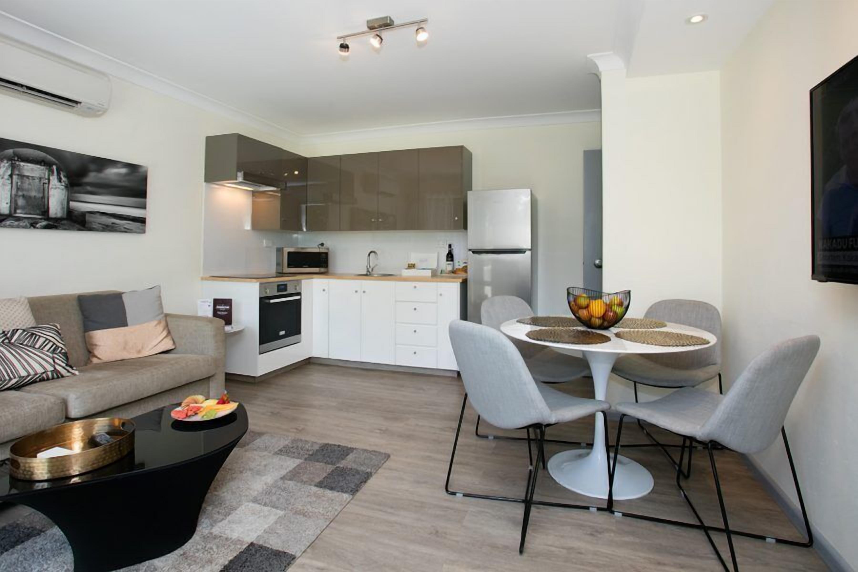 A modern apartment with a living room, kitchen, and dining area.