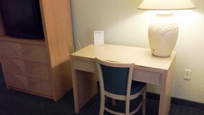 Una scrivania, postazione laptop, tende oscuranti, ferro/asse da stiro