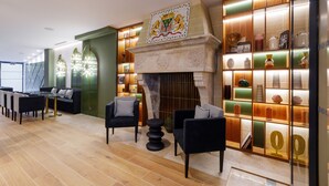A modern lobby with a fireplace, seating area, and a display of decorative items. - Star Champs Elysées (Paris)