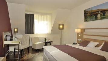 Une chambre d’hôtel avec un lit, un bureau, deux chaises, une table avec une bouteille et des verres, et un tableau au mur.