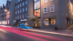En modern byggnad med en skylt som visar texten ”Apex Hotels”.
