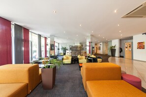 A spacious lobby with modern furniture, large windows, and a central seating area. - Novum Hotel Kavalier Wien (Vienna)