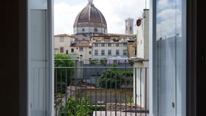 Vista des d'un balcó amb barana de metall, sobre una ciutat amb edificis històrics i una imponent estructura de cúpula.