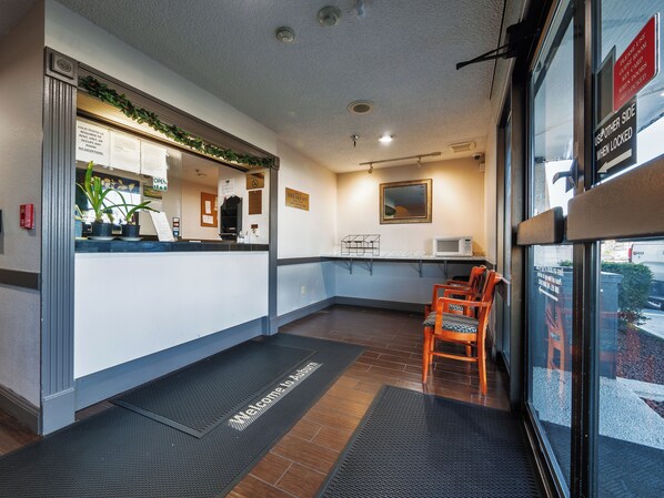 A reception area with a counter, a microwave, and a sign indicating the use of the other side when locked.