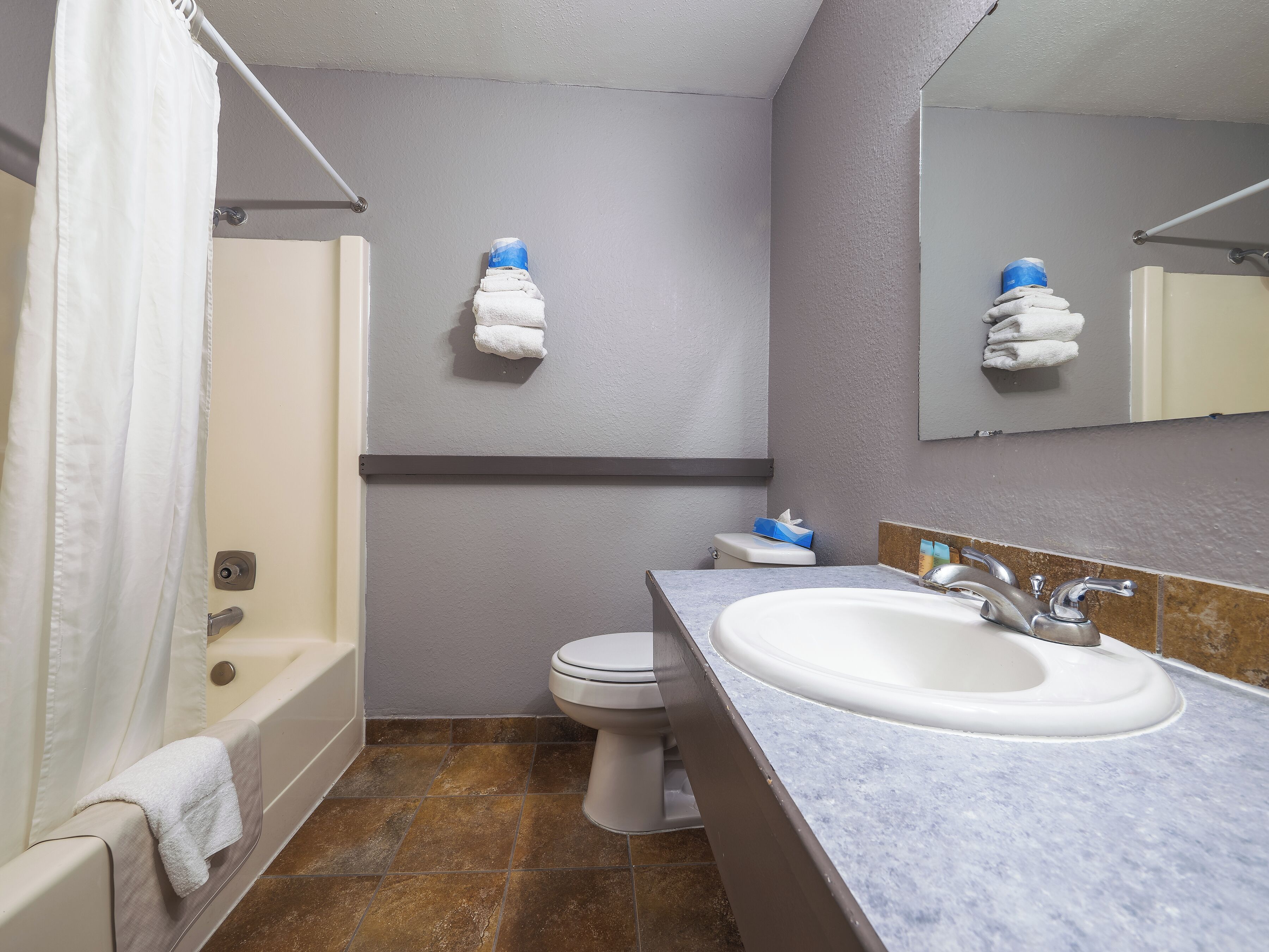 Un bagno con vasca, servizi igienici e lavandino.