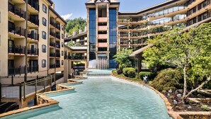 A multi-story hotel with a central water feature, balconies, and lush landscaping. - Gatlinburg Town Square (Gatlinburg)